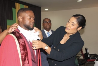 Mayor of Montego Bay, Councillor Richard Vernon, is robed by Chief Executive Officer, St. James Municipal Corporation, Naudia Crosskill, during the March 7 swearing-in ceremony at the Montego Bay Cultural Centre.

