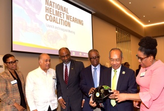 Minister of National Security and Deputy Prime Minister, Hon. Dr. Horace Chang (second right), looks at a helmet during the launch of the National Helmet Wearing Coalition Project on March 21 at the AC Hotel by Marriott in Kingston, while Executive Director, National Road Safety Council, Paula Fletcher (right), and Vice Chairman of the Council, Dr.  Lucien Jones (third right), point out the features. Others looking on (from left) are Principal Director for Transport Policy in the Ministry of Science, Energy, Telecommunications and Transport, Tanya Bedward; Chairman of Jamaica National Foundation, Parris A. Lyew-Ayee; Chief Executive Officer, Jamaica National Foundation, Earl Jarrett.

