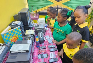 Students of the Unity Basic School look at old electronic items on display at the Jamaica Day Exhibition at the institution in St. Catherine on Friday (March 1). The items included a DVD player, antenna radios and televisions, vintage desktop computers, typewriters and cassette players. 