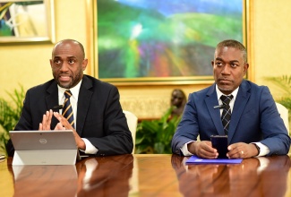 Bank of Jamaica (BOJ) Senior Deputy Governor, Dr. Wayne Robinson (left), outlines details of the new BOJ Automated Banking Machines (ABM) Service-Level Standards for Deposit-Taking Institutions (DTIs), during a Jamaica Information Service (JIS) interview. Listening is BOJ Deputy Governor with responsibility for the Central Bank’s Financial Institutions Supervisory Division, Dr. Jide Lewis.