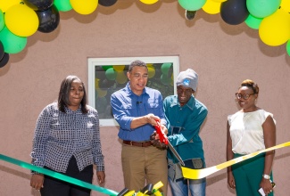 Prime Minister, the Most Hon. Andrew Holness (second left) and New Social Housing Programme (NSHP) beneficiary, Patrick Spencer (second right), cut the ribbon to officially hand over a one-bedroom unit in Button Ridge, Iron River, St. Andrew West Rural on April 12. Sharing the moment (from left) are Chair of the Oversight Committee, NSHP, Judith Robb Walters and Member of Parliament, St. Andrew West Rural and Minister of State in the Ministry of National Security, Hon. Juliet Cuthbert Flynn.