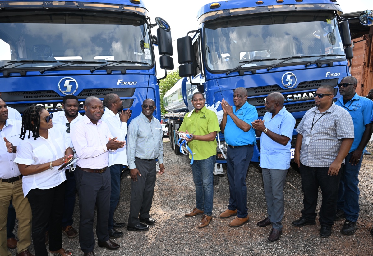 Minister of Agriculture, Fisheries and Mining, Hon. Floyd Green (fifth right); Minister of State, Hon. Franklin Witter (fourth right), and Permanent Secretary in the Agriculture Ministry, Dermon Spence (third right), are joined by representatives of the National Irrigation Commission (NIC) and other stakeholders in the commissioning two new water trucks, provided by the NIC, at the entity’s office in Hounslow, St. Elizabeth, on Friday (April 26).