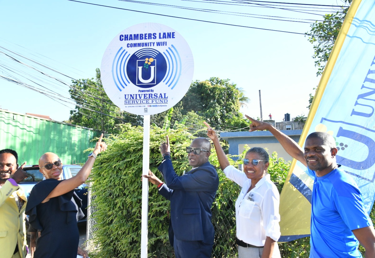 Minister of Education and Youth and St. Andrew Eastern Member of Parliament, Hon. Fayval Williams (second left), and Chief Executive Officer, Universal Service Fund (USF), Dr. Daniel Dawes (centre), point to the Chambers Lane Wi-Fi sign during the launch of the service in the community on Wednesday (March 27). Others (from left) are Councillor for the Mona Division, Gary Gordon; Principal of Campion College, Grace Baston; and member of the Chambers Lane community, Tavares Charles. Introduction of the Chambers Lane Community Wi-Fi is part of efforts by the USF to close the information divide and ensure widespread internet access.