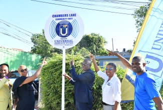 Minister of Education and Youth and St. Andrew Eastern Member of Parliament, Hon. Fayval Williams (second left), and Chief Executive Officer, Universal Service Fund (USF), Dr. Daniel Dawes (centre), point to the Chambers Lane Wi-Fi sign during the launch of the service in the community on Wednesday (March 27). Others (from left) are Councillor for the Mona Division, Gary Gordon; Principal of Campion College, Grace Baston; and member of the Chambers Lane community, Tavares Charles. Introduction of the Chambers Lane Community Wi-Fi is part of efforts by the USF to close the information divide and ensure widespread internet access.

