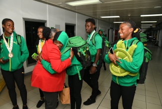 Minister of Culture, Gender, Entertainment and Sport, Hon. Olivia Grange (second left), warmly greets members of Jamaica’s victorious CARIFTA Games team on their arrival at the Norman Manley International Airport in Kingston on April 2. The team claimed Jamaica’s 38th straight CARIFTA games title, winning a total of 84 medals at the games held in Grenada from March 30 to April 1.

