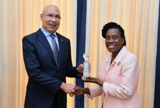 Governor-General, His Excellency the Most Hon. Sir Patrick Allen, makes a presentation to Chair, Jamaica Umbrella Groups of Churches, Reverend Elaine McCarthy, during a courtesy call at King’s House by members of the organisation on Tuesday (April 16).