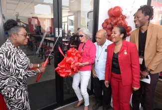 Minister of Culture, Gender, Entertainment and Sport and Member of Parliament for St. Catherine Central, Hon. Olivia Grange (left), cuts the ribbon to officially open Island Grill’s New Brunswick Village restaurant in Spanish Town on Wednesday (April 10). Celebrating the moment are (from second left)  Founder and Deputy Chairman of Island Grill, Thalia Lyn; Monsignor Gregory Ramkissoon; Chief Executive Officer of Island Grill, Tania Waldron-Gordon, and Councillor for the Spanish Town Division, Christopher Shackleford.

