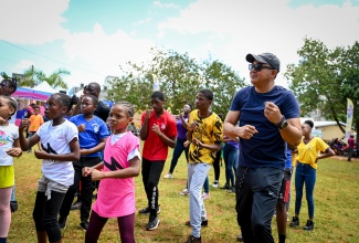 Minister of Health and Wellness, Dr. the Hon. Christopher Tufton, goes through several exercise routines with students participating in Friday’s (April 26) National School Moves Day event at Manchester High School in Mandeville.