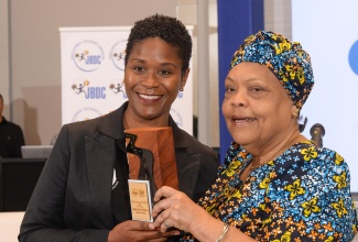 Chief Executive Officer of the Jamaica Business Development Corporation (JBDC), Valerie Veira (right), presents the ‘B.O.S.S Woman’ of the Year award to Founder and Brewer of Netty’s Farm, Eileen Dunkley-Shim, during the agency’s ‘Breakfast with the CEO’ stakeholder event, held at the AC Marriott Hotel in New Kingston, on Thursday, April 4.