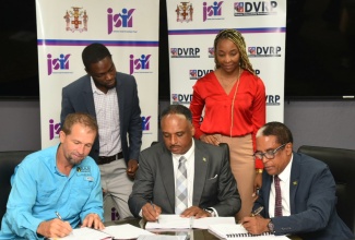 Minister of State in the Ministry of Labour and Social Security, and Member of Parliament, St. Mary South Eastern, Dr. the Hon. Norman Dunn (right, seated); Managing Director, Jamaica Social Investment Fund, Omar Sweeney (centre, seated); and Operations Director, S&G Road Surfacing Materials Limited, Anthony Sampson (left, seated), sign the $197-million contract for the Annotto Bay Coastal Protection Beach Nourishment Project during a ceremony at JSIF’s office in Kingston on Monday (April 15). Observing the signing are Project Manager, the Disaster Vulnerability Reduction Project (DVRP), JSIF, Dane McLean; and Senior Procurement Officer, JSIF, Stacey-Ann Stupart.

