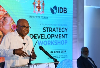 Minister of Tourism, Hon. Edmund Bartlett, speaks during the opening session of the Tourism Strategy and Action Plan Consultation Workshop for Kingston and St. Andrew, at the Spanish Court Hotel in New Kingston on Thursday (April 4). Seated is General Manager, Inter-American Development Bank (IDB) Caribbean Country Department Group and Representative in Jamaica, Anton Edmunds.