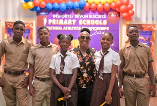 Minister of Culture, Gender, Entertainment and Sport, Hon. Olivia Grange, with primary-school student athletes at a press conference held today (April 23) at the National Indoor Sports Centre in St. Andrew. She announced increased prize money for schools participating in the INSPORTS/Devon Biscuits National Primary Schools Athletics Championship.