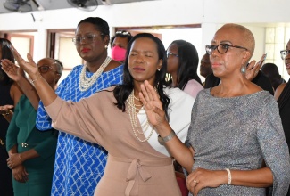 Minister of Education and Youth, Hon. Fayval Williams (right); Permanent Secretary in the Ministry, Dr. Kasan Troupe (centre); and Chief Education Officer, Terry-Ann Thomas-Gayle, raise their hands in worship at the Mathematics Week Church Service held on Sunday (April 14), at the Webster Memorial United Church in St. Andrew.