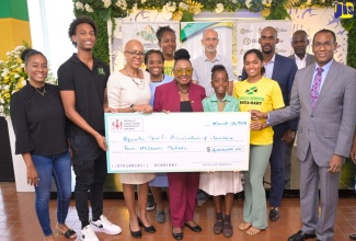 Minister of Culture, Gender, Entertainment and Sport, Hon. Olivia Grange (front, centre); is joined by Minister of Education and Youth, Hon. Fayval Williams (third left); and Minister of Finance and the Public Service, Dr. the Hon. Nigel Clarke (right), in presenting a $2-million grant, provided through the Sports Development Foundation (SDF),  to the Aquatic Sports Association of Jamaica at the Sport Ministry in New Kingston on March 20. General Manager of the SDF, Alan Beckford, is in the background, at centre. Sports associations will continue to benefit from support through the SDF in 2024/25.

