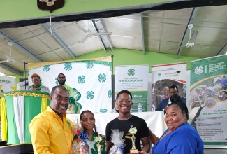 Executive Director, Jamaica 4-H Clubs, Peter Thompson (left) and Parish Manager, St. Mary 4-H Clubs, Halova Stubbs-Jones (right), present trophies and prizes to the Girl of the Year, Nickelia Ramdon of St. Mary High School and Boy of the Year,  Kymani Parkins of St. Mary Technical High.  Occasion was the St. Mary 4-H Clubs’ Parish Achievement Expo, held recently at the St. Mary High School grounds.

