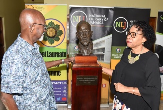 Professor Mervyn Morris (left) and Chair, Board of Management, National Library of Jamaica, Joy Douglas (right) view the honorary bust of the former Poet Laureate of Jamaica, following the unveiling ceremony held at the National Library of Jamaica in Kingston on Sunday (April 21).