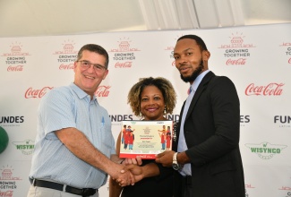 Minister without Portfolio in the Office of the Prime Minister with responsibility for Information, Skills and Digital Transformation, Senator Dr. the Hon. Dana Morris Dixon (centre), looks on as Chairman, Wisynco Group, William Mahfood (left), presents Alex Fagon with his certificate during the graduation ceremony for 350 operators in the micro, small and medium sized-enterprise (MSME) sector who participated in the Wisynco/Coca-Cola Foundation ‘Growing Together’ initiative. The ceremony was held at The Ruins, University of the West Indies (UWI) Mona on May 25.