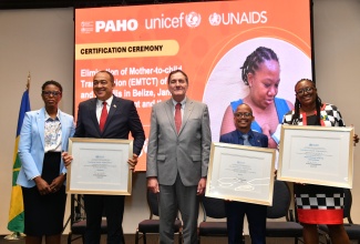 Health and Wellness Minister, Dr. the Hon. Christopher Tufton (second left);  Minister of Health and Wellness for Belize, Kevin Bernard (second right); and Representative from the Ministry of Health and Wellness in St. Vincent and the Grenadines, Arlitha John Douglas (right), display World Health Organization (WHO) certification for the Elimination of mother-to-child transmission (EMTCT) of HIV and Syphilis in their countries. Sharing the moment are Pan American Health Organization (PAHO) Director, Dr. Jabas Barbosa (centre), and Assistant Director, Dr Rhonda Sealy-Thomas. The certification ceremony was held on Tuesday (May 7) at The Jamaica Pegasus hotel in St. Andrew.

