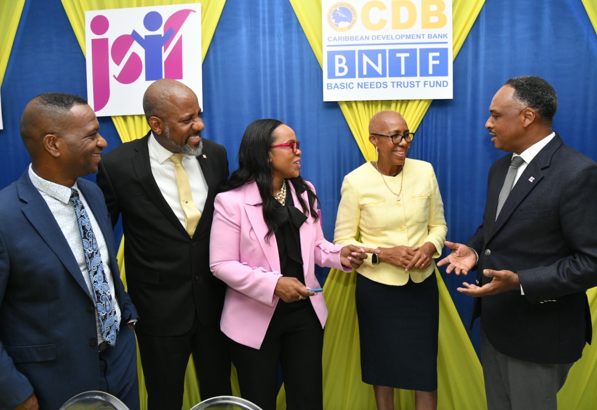 Managing Director, Jamaica Social Investment Fund (JSIF), Omar Sweeney, engages in light conversation with (from left), President of The Mico University College, Dr. Asburn Pinnock; JSIF Board Chairman, Dr. Wayne Henry; Permanent Secretary in the Ministry of Education and Youth, Dr. Kasan Troupe; and Minister of Education and Youth, Hon. Fayval Williams. Occasion was the recent signing of a contract under the Basic Needs Trust Fund (BNTF), to strengthen capacity in special education, held at The Mico campus in Kingston.