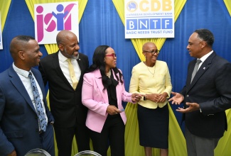 Managing Director, Jamaica Social Investment Fund (JSIF), Omar Sweeney, engages in light conversation with (from left), President of The Mico University College, Dr. Asburn Pinnock; JSIF Board Chairman, Dr. Wayne Henry; Permanent Secretary in the Ministry of Education and Youth, Dr. Kasan Troupe; and Minister of Education and Youth, Hon. Fayval Williams. Occasion was the recent signing of a contract under the Basic Needs Trust Fund (BNTF), to strengthen capacity in special education, held at The Mico campus in Kingston.