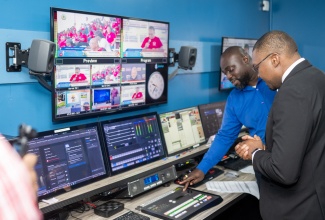 Minister without Portfolio in the Office of the Prime Minister with Responsibility for Information, Hon. Robert Morgan (left), looks at multimedia equipment during a tour of Guyana’s State news agency, National Communications Network (NCN) on Thursday  (May 2). Minister Morgan is in Georgetown for UNESCO World Press Freedom Day observances

