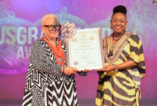 Minister of Culture, Gender, Entertainment and Sport, Hon.  Olivia Grange (right), presents noted choreographer and dancer, Dr. L’Antoinette Stines, with her silver Musgrave Medal for achievement in the arts (dance), at the awards ceremony held recently at the Philip Sherlock Centre for the Creative Arts on the Mona campus of the University of the West Indies (UWI) in St. Andrew.