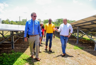 Minister of Science, Energy, Telecommunications and Transport, Hon. Daryl Vaz (left), in conversation with Chief Executive Officer of the Caribbean Broilers (CB) Group, Matthew Lyn (right), at the commissioning of solar plants for the Group, at their Peninsula Farms in Banbury, St. Catherine, on May 7. Pictured at second right is Member of Parliament for St. Catherine North Western, Hugh Graham.

