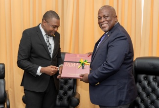 Minister without Portfolio in the Office of the Prime Minister with responsibility for Information, Hon. Robert Morgan (left), presents a book entitled ‘Jamaica: Heritage in Pictures’ to Prime Minister of Guyana, Hon. Brigadier (Ret