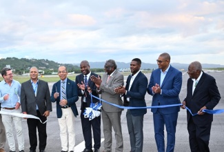 Deputy Prime Minister and Minister of National Security, Hon. Dr. Horace Chang (third left), cuts the ribbon to officially open the extended runway at the Sangster International Airport (SIA) in Montego Bay, St. James on Thursday [May 2]. Joining him (from left) are Chairman of the Airports Authority of Jamaica [AAJ], Mark Hart; AAJ President & Chief Executive Officer, Audley Deidrick; Chief Executive Officer of MBJ Airports Limited, Shane Munroe; Custos of St James, Bishop Conrad Pitkin; Montego Bay Mayor, Richard Vernon; Opposition Spokesperson on Housing, Transportation, and Works, Mikael Phillips; and Chairman of the Tourism Enhancement Fund (TEF), Godfrey Dyer