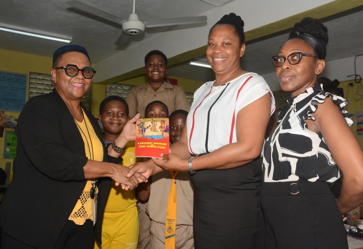 Special Projects Manager at the Jamaica Information Service (JIS), Montego Bay Regional Office, Sharon Earle (left), gifts grade-four teacher at Glendevon Primary School in St. James, Tessah Whittingham (centre) and Literacy Coordinator, Delfern Lewis, a JIS publication, ‘A Different Hurricane and Other Jamaican Stories’, to aid students in their reading and comprehension skills, on Read Across Jamaica Day, Tuesday, May 7.