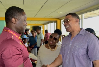 D: Prime Minister, the Most Hon. Andrew Holness (right), greets former cricketer Wavell Hinds, during Saturday’s T20I Cricket Match between West Indies and South Africa at Sabina Park in Kingston. Sharing the moment is Minister of Culture, Gender, Entertainment and Sport, Hon. Olivia Grange.