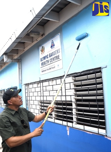 Prime Minister, the Most Hon. Andrew Holness (right), paints the exterior walls of the Olympic Gardens Health Centre in Kingston on Labour Day (May 23).