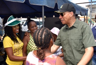 Prime Minister, the Most Hon. Andrew Holness (right), interacting with community members during his visit to the Olympic Gardens Health Centre in Kingston to participate in Labour Day (May 23) activities.