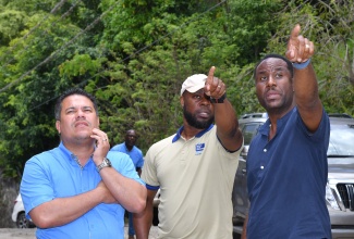 Minister without Portfolio in the Ministry of Economic Growth and Job Creation, Senator the Hon. Matthew Samuda (left), looks at something of interest being pointed out by Vice President, National Water Commission (NWC), Herman Fagan (centre) and Water Supply Manager, Chadron Stern, during a tour of water projects in East Rural St. Andrew on Friday (May 24).