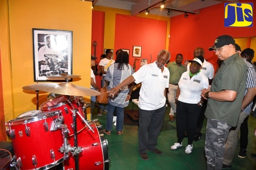 Prime Minister, the Most Hon. Andrew Holness (right) and Minister of Culture, Gender, Entertainment and Sport, Hon. Olivia Grange (second left), look on as Jamaica Music Museum Director, Herbie Miller (left), points out features of musical equipment, during a tour of the facility, downtown Kingston, today (May 23). Leader of the Opposition, Mark Golding (partially hidden) was also on the tour.