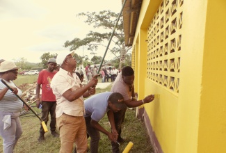 Mayor of Spanish Town, Councillor Norman Scott (second right), joins officers of the St. Catherine Municipal Corporation in painting the exterior walls of the Lluidas Vale Community Centre, during Labour Day activities on Thursday (May 23). The refurbishing of the Community Centre, including the construction of a wheelchair access ramp, was the St. Catherine parish project.