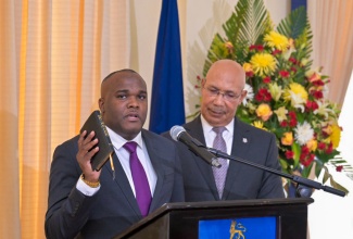 Governor-General His Excellency the Most Hon. Sir Patrick Allen  (right) listens as newly appointed Parliamentary Secretary, Senator Abka Fitz-Henley (centre) takes the Oath of Allegiance and the Oath of Office during the swearing-in ceremony held at King’s House on May 22.