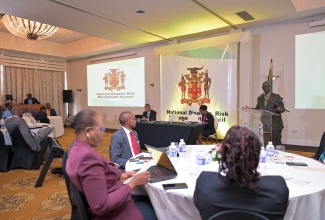 Minister of Local Government and Community Development, Hon. Desmond McKenzie (at lectern), addresses the National Disaster Risk Management Council meeting at Sandals Ochi Beach Resort in St. Ann on Wednesday (May 29). 