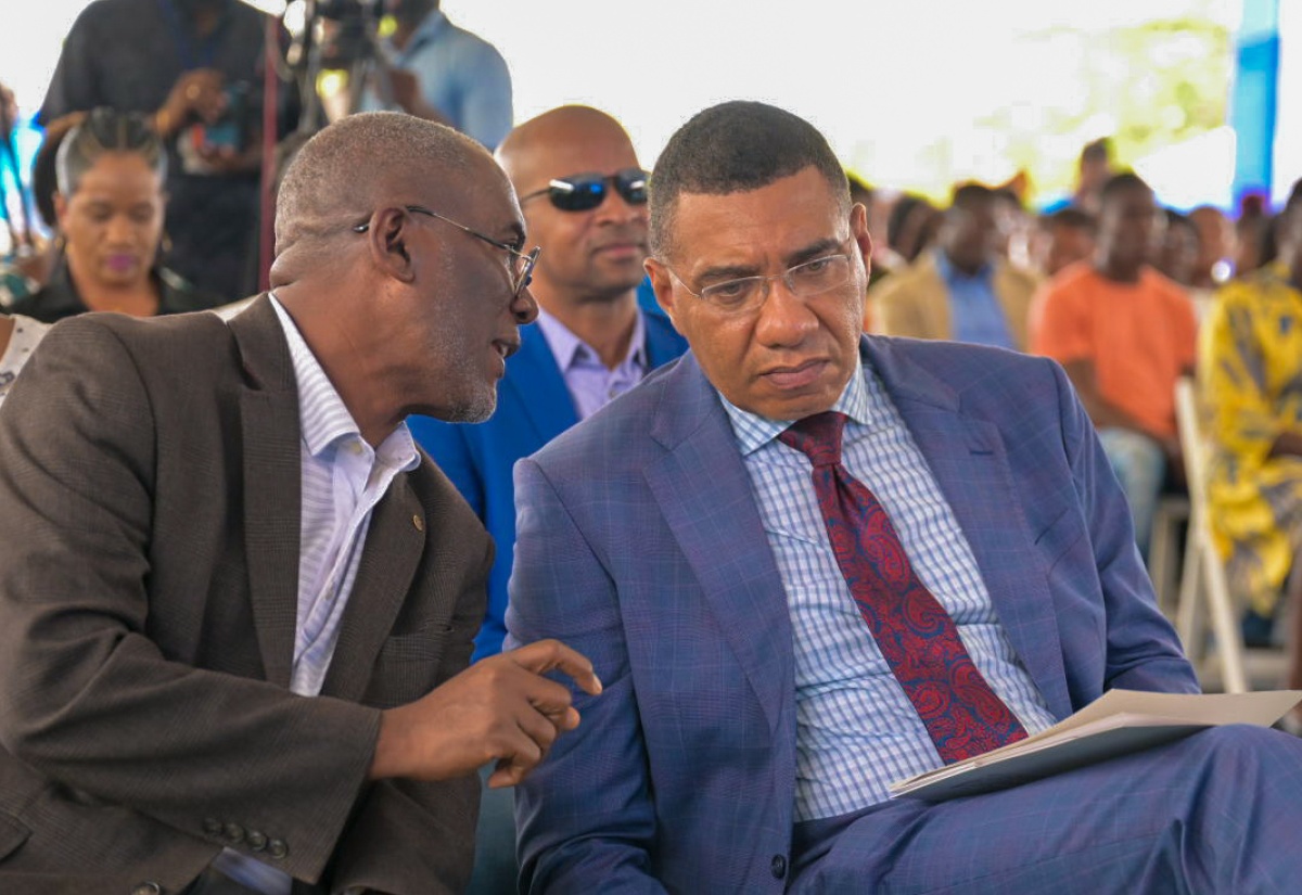 Prime Minister, the Most Hon. Andrew Holness (right), converses with National Housing Trust (NHT) Chairman, Linval Freeman, during the official handover of residential serviced lots under the new Friendship Oaks Phase 1 development in Goshen, St. Elizabeth, on May 17.