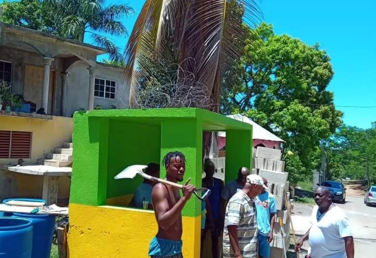 Volunteers from the Exchange District in St. Ann paint the bus stop in Jamaican colours on Labour Day, May 23.

