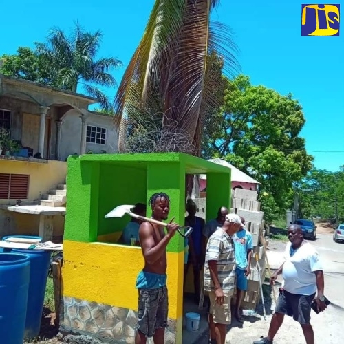 Volunteers from the Exchange District in St. Ann paint the bus stop in Jamaican colours on Labour Day, May 23.