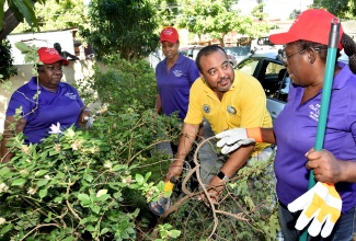 2023/24 Civil Servant of the year in the Managerial category, Opal Bryan (right), engages with President of the North St. Andrew Kiwanis Club, Jason McIntosh, during a Labour Day project at Reddies Place of Safety in Kingston on May 23. Looking on are Civil Servants of the Year in the Technical Support and Mid-Managerial categories respectively, Christine Rowe (left) and Ruth McGrowder. The Labour Day activity included repairs to sections of the Reddies Place of Safety, painting and general cleaning and beautification.
