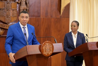 Prime Minister, the Most Hon. Andrew Holness, addresses Wednesday’s (May 15) post-Cabinet press briefing at Jamaica House. Listening is Minister of Legal and Constitutional Affairs, Hon. Marlene Malahoo Forte. 