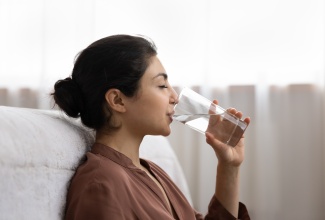 Young Indian woman drinking water from a glass