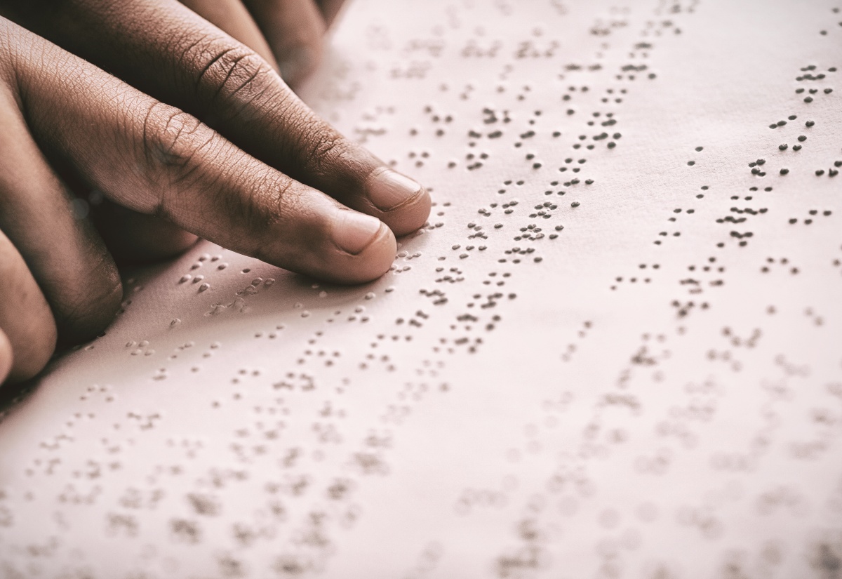 Cropped image of a person using braille to read. 