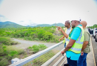 Minister without Portfolio in the Ministry of Economic Growth and Job Creation with Responsibility for Works, Hon. Robert Morgan (foreground), highlights aspects of work along a segment of the Southern Coastal Highway Improvement Project (SCHIP), between Harbour View, St. Andrew and Golden Grove, St. Thomas, to National Works Agency (NWA) Senior Director for Project Implementation, Varden Downer (left), and St. Thomas Western Member of Parliament, James Robertson, during a tour on Friday (June 7).