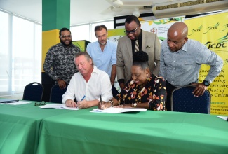 Culture, Gender, Entertainment and Sport Minister, Hon. Olivia Grange (right) and Managing Director of J. Wray & Nephew Limited, Jean-Phillippe Beyer, sign an agreement for $20 million in sponsorship support for Emancipation/Independence celebrations. The signing ceremony was held on Wednesday, June 12, at the Ministry’s New Kingston offices. Witnessing are (from left) Communications Manager, J. Wray & Nephew, Dominic Bell; Marketing Manager, Stefano Furini; Permanent Secretary in the Ministry of Culture, Gender, Entertainment and Sport, Deanroy Bernard; and Chief Executive Officer, Jamaica Cultural Development Commission (JCDC), Lenford Salmon. 