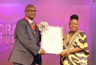 Minister of Culture, Gender, Entertainment and Sport, Hon. Olivia Grange (right) presents Dr. Conrad Douglas with the Silver Musgrave Medal for his work in Applied Science, Technology and Innovation in Industry and the Environment, during the awards ceremony at the Philip Sherlock Centre for the Creative Arts recently.