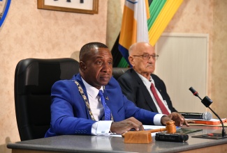 Mayor of Kingston, Councillor Andrew Swaby (left), addresses the Kingston and St. Andrew Municipal Corporation (KSAMC) recent monthly sitting. The meeting was held at the Corporation’s Chambers in downtown Kingston. Beside Councillor Swaby is former Jamaica Olympic Association (JOA) President, Mike Fennell, who was a guest at the sitting.

