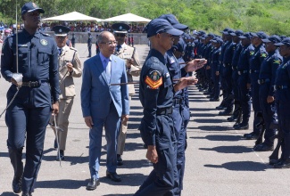 Minister of National Security, Hon. Dr. Horace Chang (centre),  inspects new police recruits on parade at the National Police College of Jamaica, at Twickenham Park, in St. Catherine, on June 25.